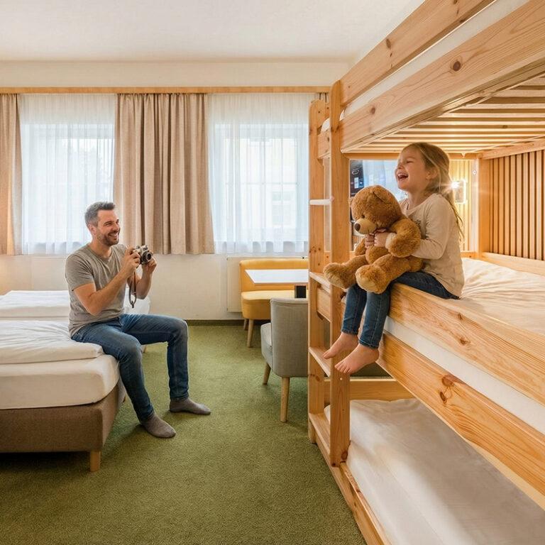 Mutter und Vater fotografieren Tochter mit Teddy im Stockbett